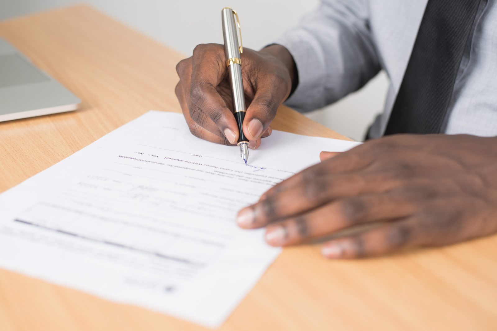 close up of man writing on paper