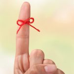 Rope bow on finger pointing up on background